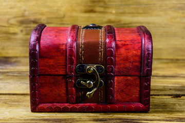 Closed vintage chest from red wood on wooden background