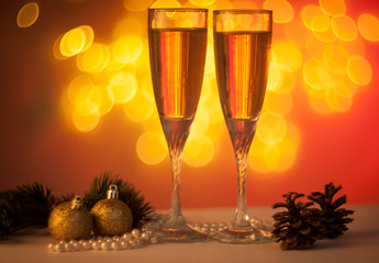 two glasses of champagne and decorations on red background