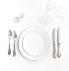 New luxury white ceramic plate, silver vintage cutlery view from above on a isolated background. Top view..Knife and fork for a festive table for a wedding, birthday or party.