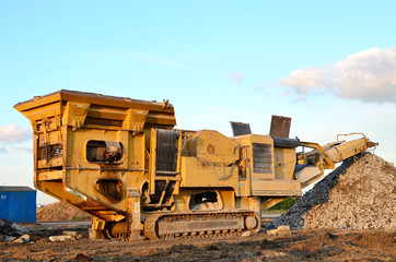 Mobile Stone crusher machine by the construction site or mining quarry for crushing old concrete slabs into gravel and subsequent cement production