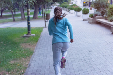 Running woman. Female fitness model training outside in the city.