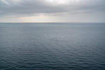 Obraz premium Blue sea surface with small waves in cloudy day.