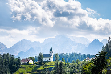 Church Cerkev Sveti Duh with mountain range Kamnik–Savinja Alps