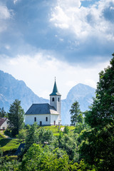 Fototapeta na wymiar Church Cerkev Sveti Duh with mountain range Kamnik–Savinja Alps