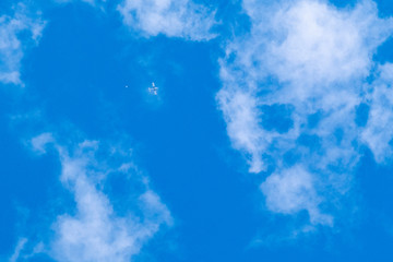 un avion au loin dans le ciel largue un parachutiste