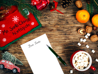 Letter to Santa Claus concept. Paper on wooden background with Cristmas decoration and cup of hot chocolate, top view, copy space