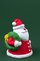 Funny gypsum colorful santa claus isolated over green background. New Year and Christmas concept.