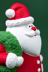 Close-up photo of gypsum colorful santa claus isolated over green background. New Year and Christmas concept.