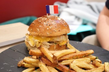 Hamburger accompagné de frites sur une planche en ardoise