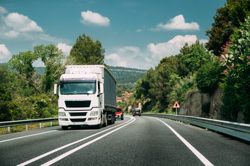 White Truck Or Tractor Unit, Prime Mover, Traction Unit In Motion On Road, Freeway. Asphalt Motorway Highway Against Background Of Hill Landscape. Business Transportation Trucking Industry © Great Brut Here