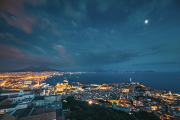 Naples, Italy. Skyline Cityscape In Evening Lighting. Tyrrhenian Sea And Landscape With Volcano Mount Vesuvius. City In Night Illuminations