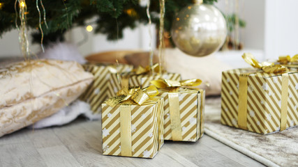 Fototapeta na wymiar Gold boxes of presents under the Christmas tree