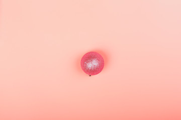 Christmas minimalistic background. Christmas ball on a pink background. pink glitter christmas toy. top view, flat style