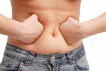 Naklejka premium the girl presses the fat on her stomach with two fists inside. front view, white background