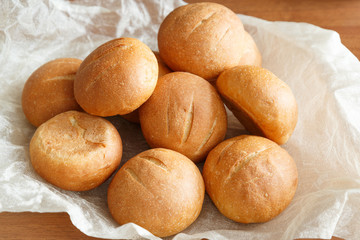 small round buns for Breakfast on a lighter background fabric on a wooden table
