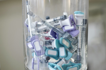 Tuberculin Syringe and Sterile Vial Filled with Medication Solution. A syringes for injection in a glass vase