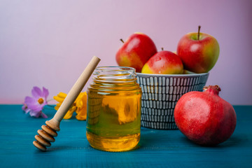 Jar of honey, apples and pomegranates on the table for the holiday of Rosh Hashanah