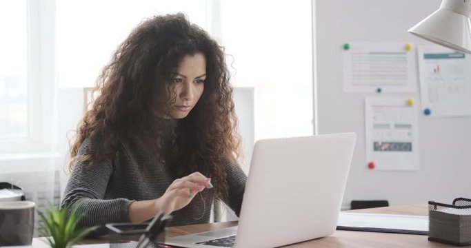 Displeased businesswoman closing laptop after receiving bad news online at office