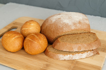 rye bread and scones on wooden Board on grey background