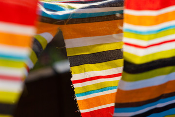 Brightly colored striped fabric with tear