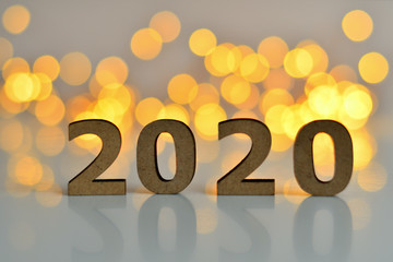 wooden numbers 2020 on a pink background with bokeh New Year's lights.The concept of the New Year, New Year's Eve, winter holidays.
