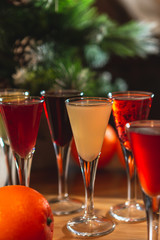 many glasses of shot or liqueur. Friends drink shot or liqueur and cheers. alcohol on blurred table background. Party and toast concept.