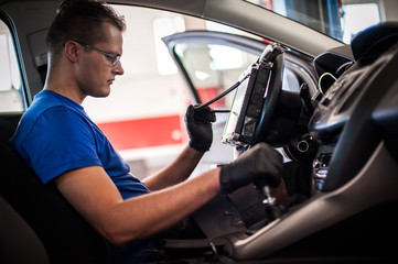 Automobile computer diagnosis. Car mechanic repairer looks for engine failure