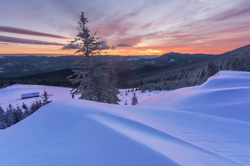 Colorful winter dawn on the mountain valleys in the Ukrainian Carpathian Mountains.	