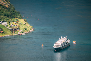 Geirangerfjord, Norway. Touristic Ship Ferry Boat Floating Liner Moored Near Geiranger In Geirangerfjorden In Spring Summer Day. Famous Norwegian Landmark And Popular Destination