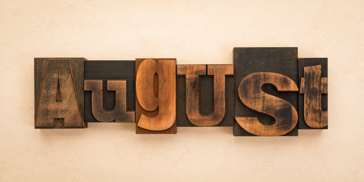 August, word written with vintage letterpress printing blocks on textured background