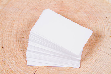 Stack of blank white business cards on a wooden background
