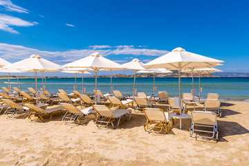 Parasols and sunbeds on Agios Georgios beach, very popular resort with fine golden sand and crystal...