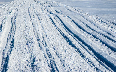 ATV and ski tracks in snow on frosty winter day