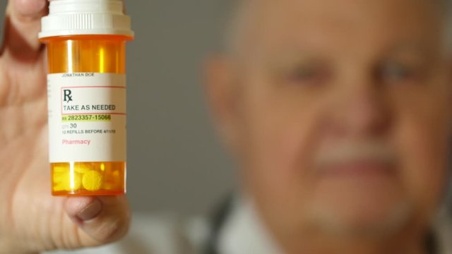 Close up of a mature doctor holding medication