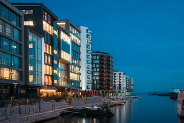 Foto op Plexiglas Oslo, Norway. Night View Embankment And Residential Multi-storey Houses In Aker Brygge District. Summer Evening. Residential Area Reflected In Sea Waters. Famous And Popular Place © Grigory Bruev