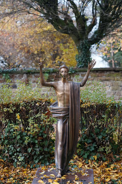 Statue auf einem Grab vor der Friedhofsmauer