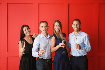 Group of friends with glasses of champagne on color background