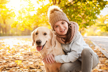 Little girl with cute dog in autumn park