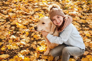 Little girl with cute dog in autumn park