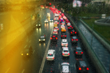 Blurry lights of high traffic cars. Bokeh Traffic on the highway in the city. Glowing lights. Bad weather for driving.