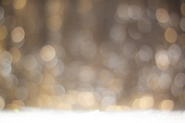 Christmas bright background with silver and gold colors bokeh and snowflakes at the table. Holiday...