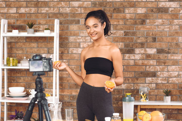 African-American blogger recording video about sport and healthy food at home
