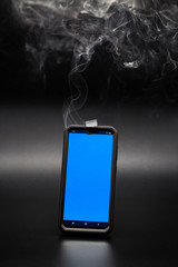 smoke coming from a smartphone with tape covering the phones camera