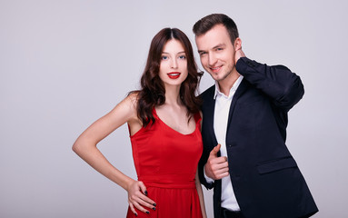 Stylish couple in bright clothes smiling.