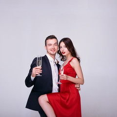 Sexy young couple hugs, drinks champagne, celebrates new year.