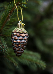 Glass Christmas cone on a spruce branch.