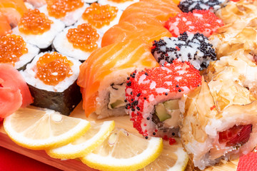 Fototapeta na wymiar Sushi set of rolls and poppies, with salmon and caviar. Close-up.