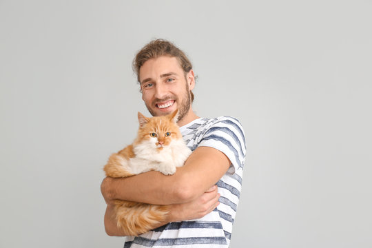 Man With Cute Cat On Light Background