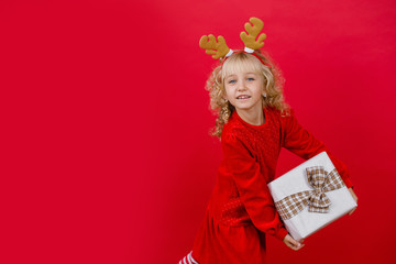 Happy excited girl child holding christmas gift box.