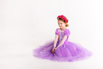 Obraz na płótnie Canvas Little blonde girl wearing purple fairy princess dress on white background. Kids costume for new year party